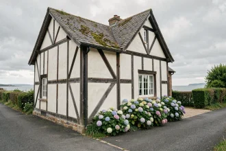 Maison normande à colombages traditionnelle avec vue sur la mer en Normandie, jardin fleuri et toiture en ardoise